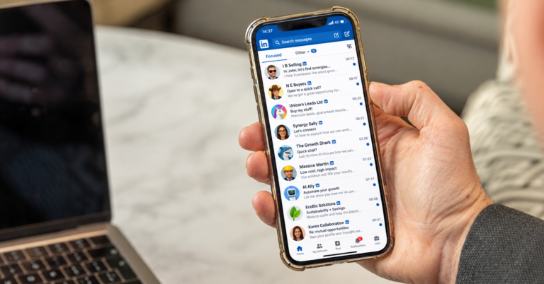 LinkedIn inbox on a phone full of generic cold pitch messages, such as "let's find synergies" and "open to a quick call?"